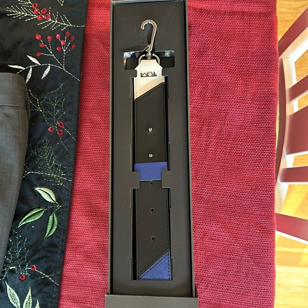 New in box Tumi leather strap- never removed from box - box has small damage